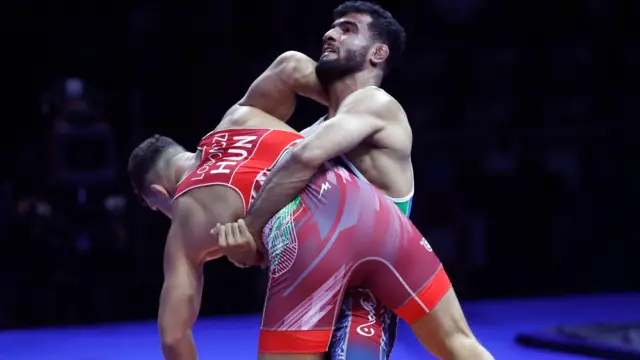 داوید لوسونچی از مجارستان (قرمز) در حال مبارزه با علیرضا مهمدی از ایران (آبی) در جریان مسابقه نیمه نهایی وزن ۸۷ کیلوگرم فرنگی مردان مسابقات قهرمانی کشتی جهان ۲۰۲۵ در زاگرب، کرواسی