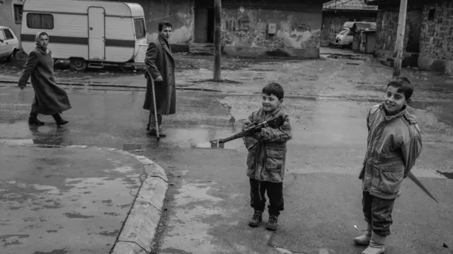 Crno-bela fotografija dečje igre na ulicama Sarajeva pod opsadom