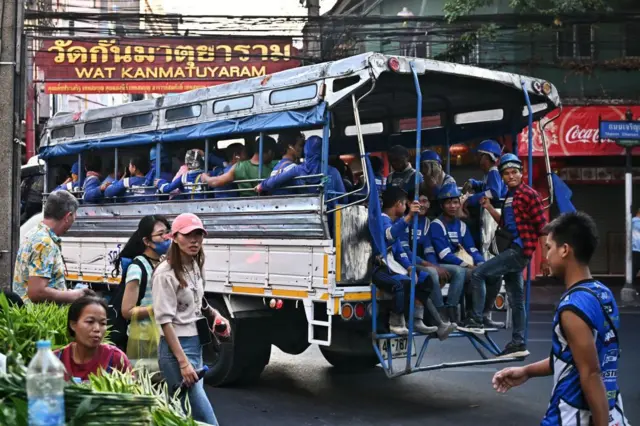 Construction workers leave a construction site in the back of a truck in Chinatown in Bangkok on January 3, 2024.