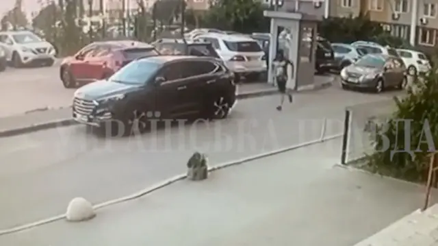 Umugabo ugaragara ko yambaye ikabutura yijimye n'umwambaro utamenwa n'amasasu asanzwe, aboneka arimo kwiruka yerekeza muri parikingi y'imodoka i Kyiv, muri Ukraine.