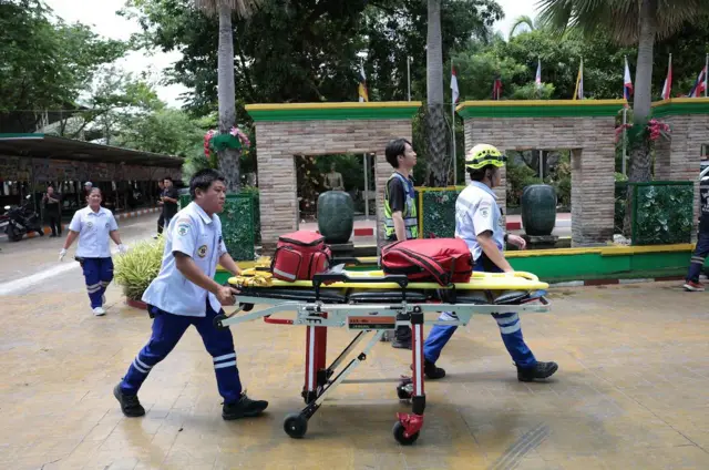 Nhân viên cứu hộ làm việc bên ngoài Trường Debsirin Nonthaburi, nơi xảy ra vụ nổ súng