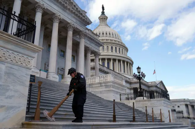 Funcionário arruma cordão de isolamento em escadaria do Capitólio, durante o dia