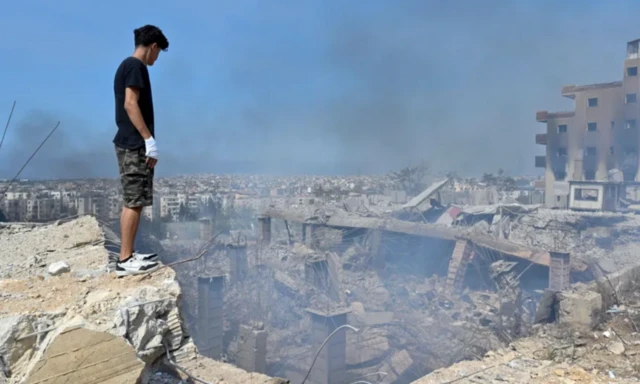 தென்கிழக்கு பெய்ரூட்டில் நடைபெற்ற இஸ்ரேலிய தாக்குதலால் ஏற்பட்ட சேதங்களை பார்க்கும் இளைஞர்