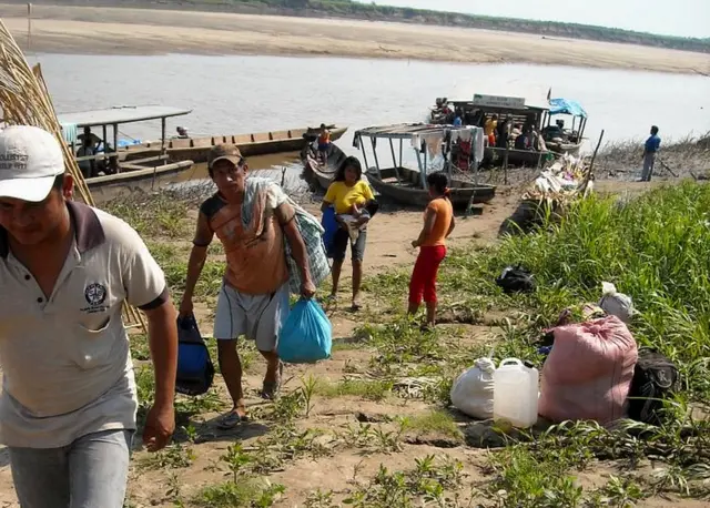 Marchistas llegan al punto de concentración de la marcha en embarcaciones