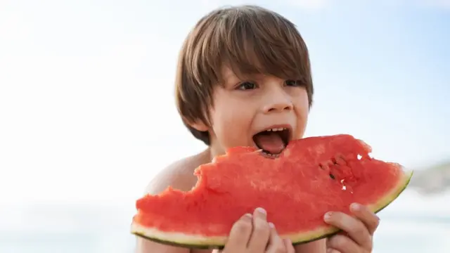 Criança comendo melancia