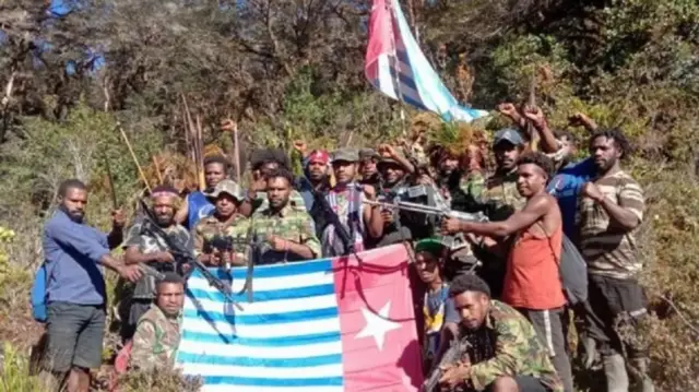 Anggota Tentara Pembebasan Nasional Organisasi Papua Merdeka memegang bendera Bintang Kejora.