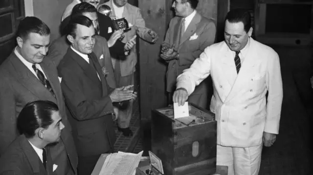 Juan Domingo Perón insertando su voto en una urna. 