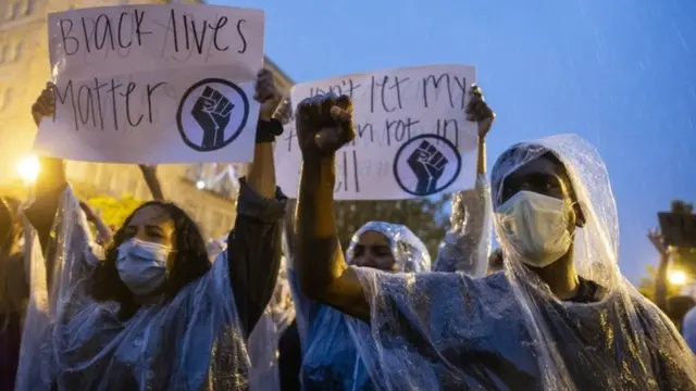 People gather in the rain outside of the White House for a peaceful protest