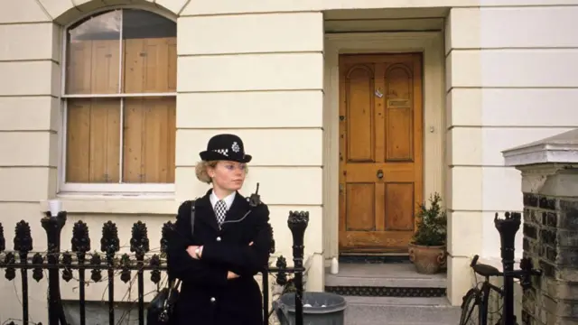 یک افسر پلیس زن به دنبال فتوای آیت الله خمینی در ۲۷ بهمن ۱۳۶۷ در لندن، از خانه سلمان رشدی، محافظت می کند