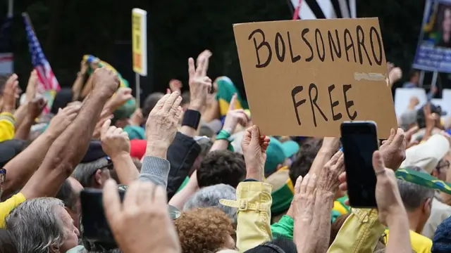 Cartaz, em meio a multidão, com os dizeres "Bolsonaro free". 