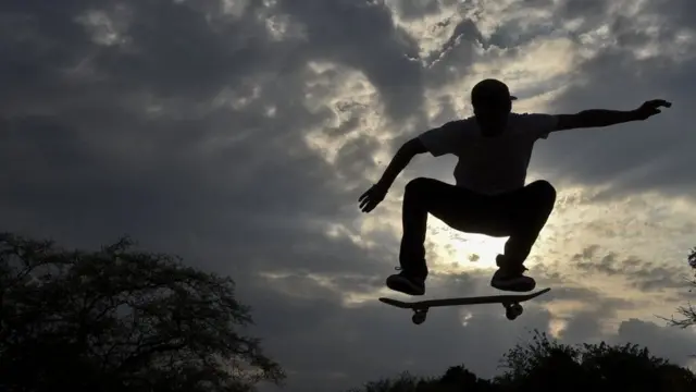 Homem faz manobrasimulador de apostas esportivasskate no ar