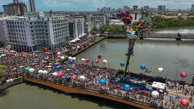 Esta vista aérea mostra foliões participando do desfile do bloco Galo da Madrugada nas ruas de Recife