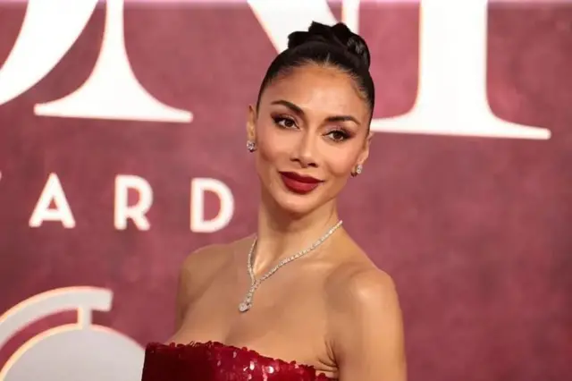 چهره نیکول شرزینگر در برابر دوربین ژست گرفته، لبخند می‌زند