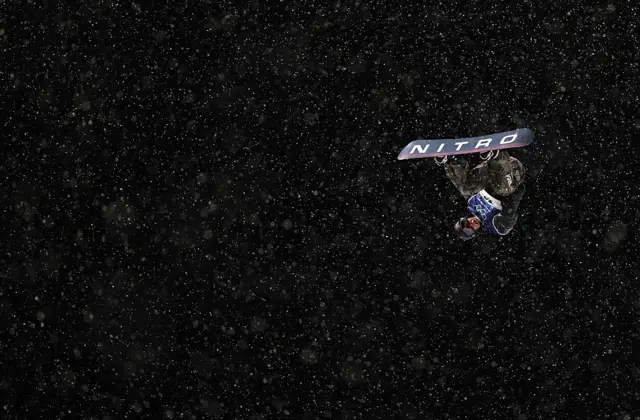 El surcoreano Geonhui Kim de cabeza, durante un salto de snowboarding en Milán-Cortina 2026