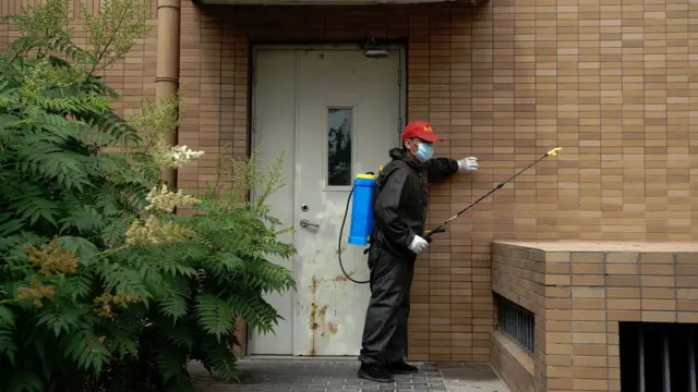 Un voluntario desinfectando un apartamento en Pekín.