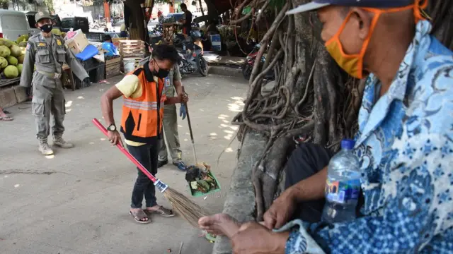Warga diberi sanksi menyapu di Pasar Induk Kramat Jati, Jakarta