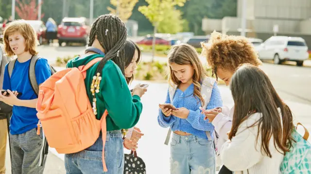 Meninas em roda, todas mexendo cada uma em seu celular