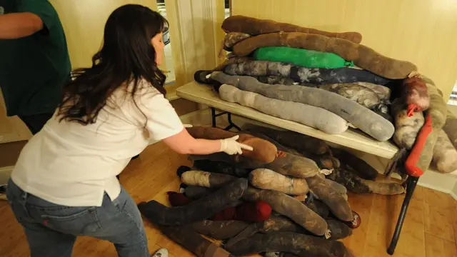 Una mujer arruma unos cilindros llenos de pelo humano