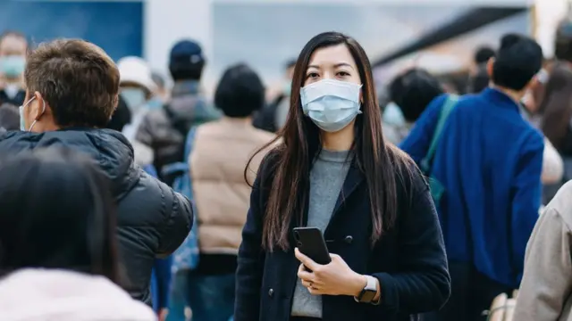 Mujer con mascarilla en la calle