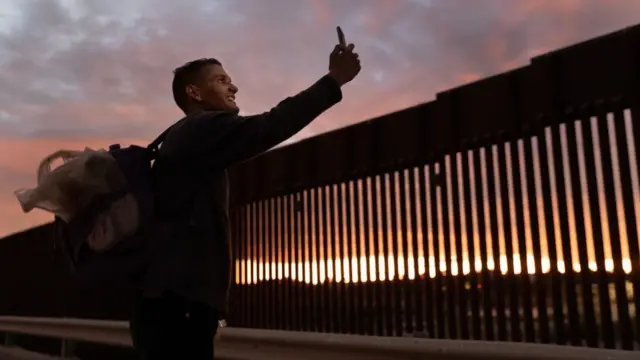 Un migrante venezolano sonriente tras cruzar la frontera de México a Estados Unidos.