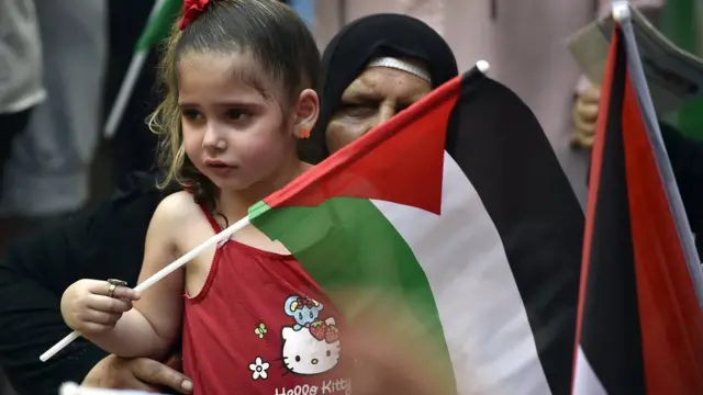 طفلة تحمل العلم الفلسطيني