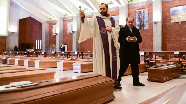 Интерьер церкви, священник освещает гробы