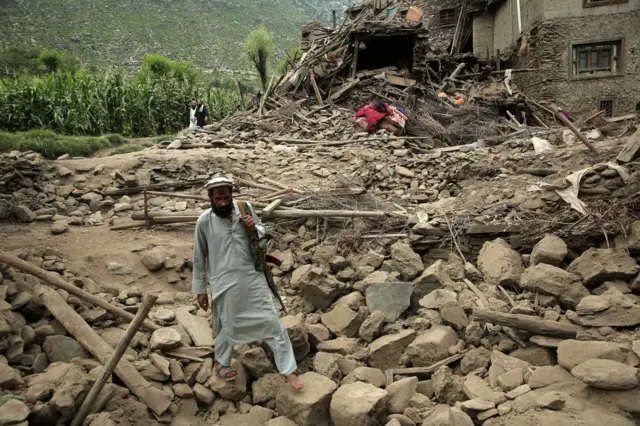 Mandatory Credit: Photo by SAMIULLAH POPAL/EPA/Shutterstock (15466834y)
A man walks over rubble next to a damaged house after an earthquake in Kunar, Afghanistan, 01 September 2025. At least 800 people have been killed and some 2,000 injured after a shallow magnitude-6.0 earthquake and several aftershocks shook Nangarhar and Kunar in eastern Afghanistan overnight, officials reported on 01 September 2025.
Hundreds killed, thousands injured after earthquake hits Afghanistan, Kunar - 01 Sep 2025