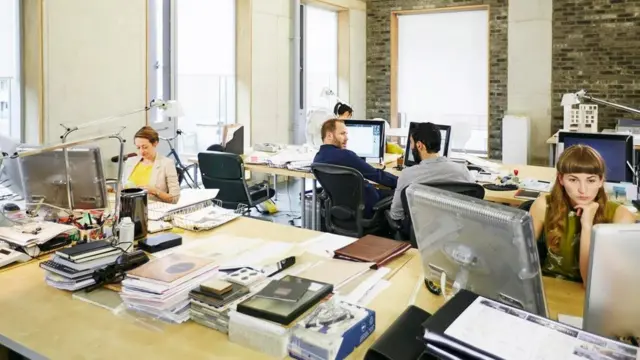 Personas en una persona. Una de ellas mira su teléfono