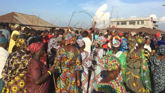 Awọn obinrin to n wọ tẹle egungun lẹyin pẹlu ọrẹ ni ọwọ wọn