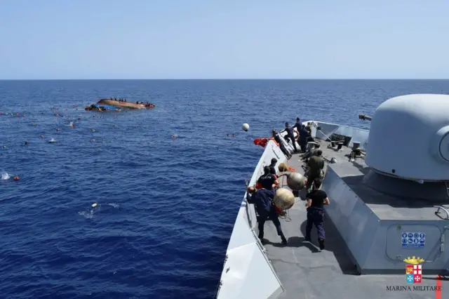 Migrants escape from a capsizing boat in the Mediterranean, 25 May