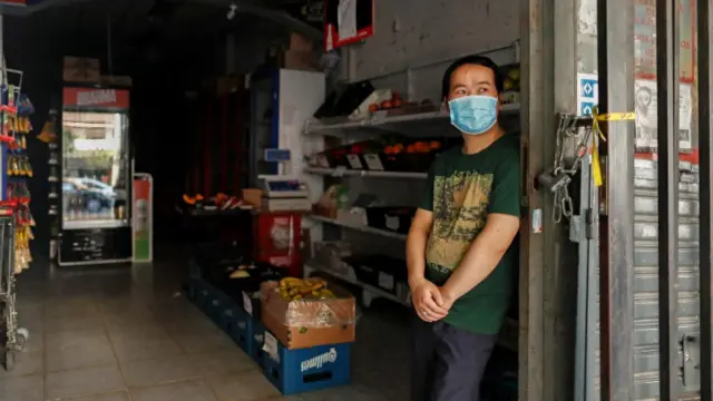 El dueño de una tienda aguarda la llegada de clientes durante el apagón