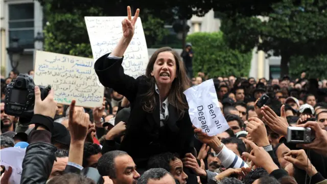 الأمينة العامّة السابقة للحزب الديمقراطي التقدّمي المعارض(الحزب الجمهوري لاحقا)، المرحومة ميّه الجريبي فوق أكتاف متظاهرين أمام وزراة الداخلية التونسية (14 يناير كانون الثاني 2011)