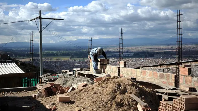 Un albañil construyendo una casa en un cerro de Bogotá.