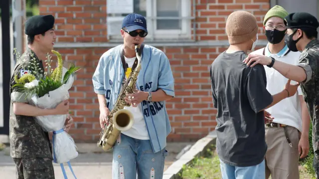 BTS 리더 RM(왼쪽 두번째)이 12일 오전 경기도 연천 소재 육군 제5보병사단 신병교육대대에서 육군 현역으로 군 복무를 마친 진을 색소폰 연주로 축하하고 있다