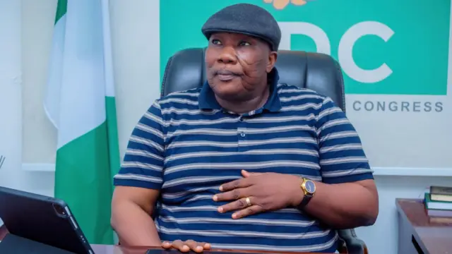 Onarebu Salaam ree pẹlu fila bẹntigọọ lori, to si gbe ọwọ si iku rẹ, o n wo
