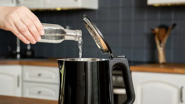 Vinagre sendo despejado em um eletrodoméstico na cozinha