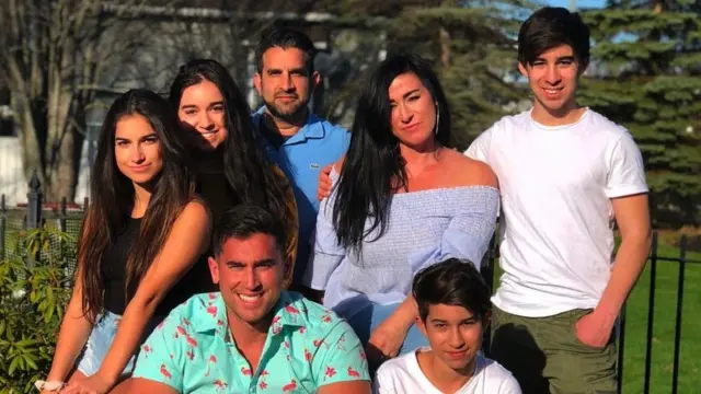 A group photo showing the seven members of the Anand family, including Liam