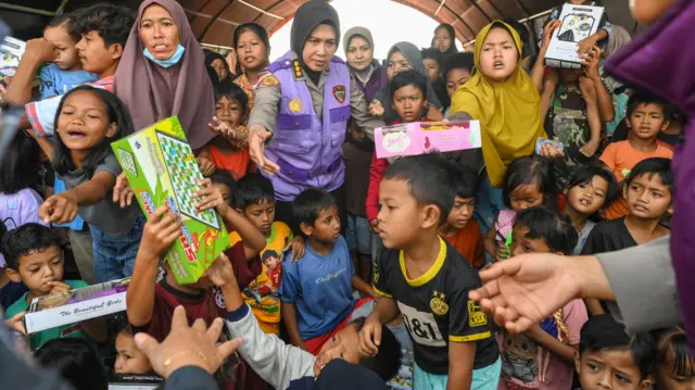 Sejumlah anak-anak pengungsi menerima mainan di posko pengungsian Kuala Simpang, Aceh Tamiang, Aceh, Jumat (12/12/2025). 