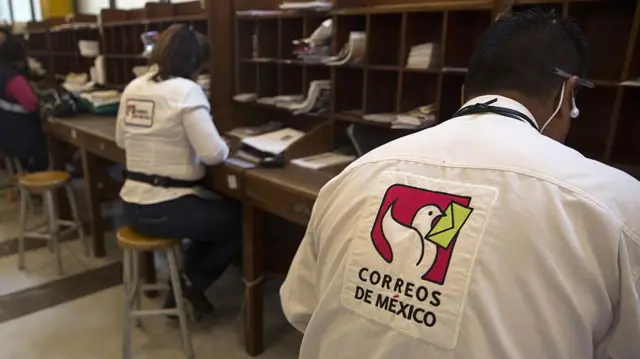 Trabajadores de Correos de México procesando paquetes