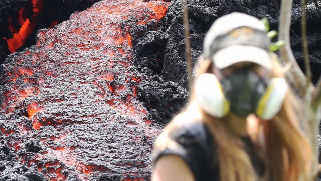 Una mujer camina junto a una fisura causada por la irupción del volcán Kilauea.