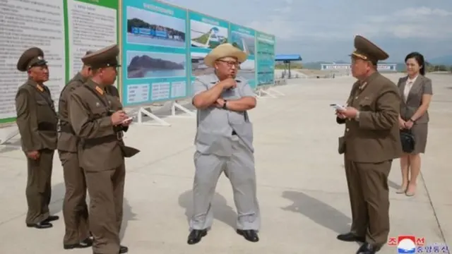 Kim Jong-un chuyện trò với các quan chức nhà máy ướp cá trong khi Đệ nhất Phu nhân Ri Sol-ju đứng nhìn