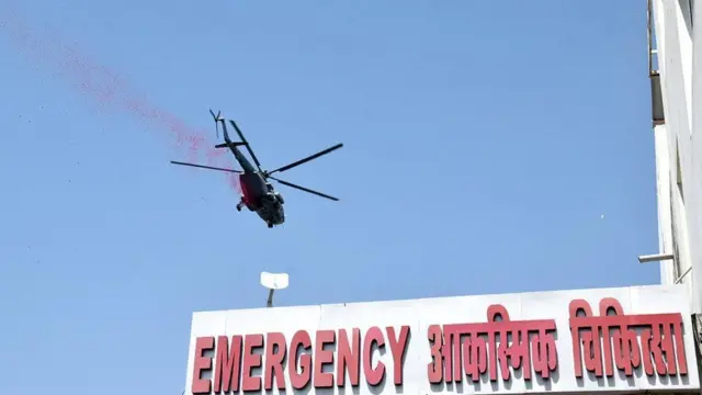 சுகாதார ஊழியர்களுக்காக வானில் இருந்து பூக்களைத் தூவும் ஹெலிகாப்டர்