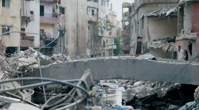 رجل يقف على جسر يتفقد الدمار في بيروت بعد هجوم 8 أبريل/نيسان.