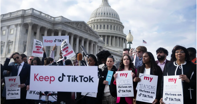 أشخاص في الولايات المتحدة يقفون حاملين لافتات تطالب بالإبقاء على تطبيق تيك توك في البلاد.