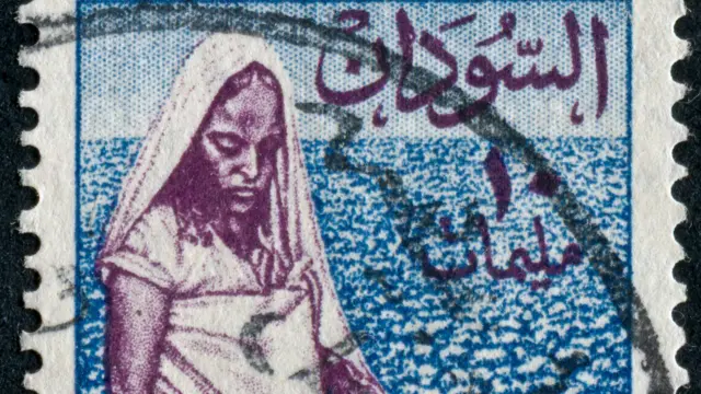 صورة لطابع سوداني قديم تظهر عليه سيدة تقطف القطن