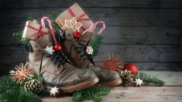 Две чизмице у којима су поклони, а око којих су новогодишњи украси