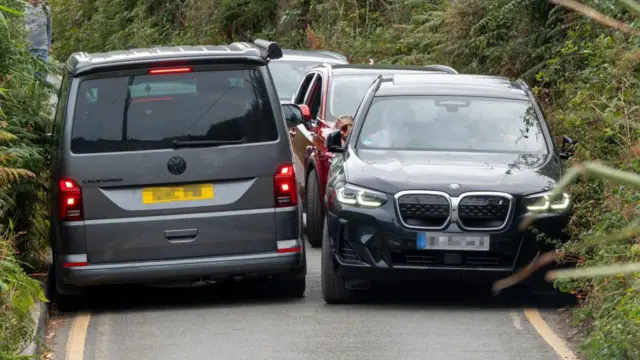 Veículos tentam se espremer entre si nas estreitas faixas da estrada em Porthcurno, na Cornualha, sudoeste da Inglaterra