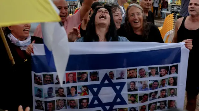 Einav Zangauker, majka taoca Matana Zangaukera, reaguje držeći izraelsku zastavu sa fotografijama talaca, nakon što je američki predsednik Donald Tramp objavio da su se Izrael i Hamas dogovorili o prvoj fazi primirja u Gazi, na „Trgu talaca“ u Tel Avivu.