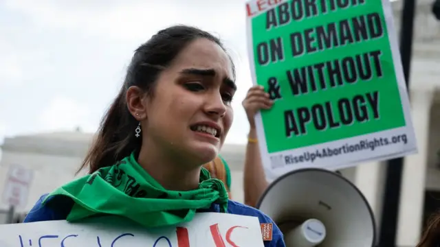 গর্ভপাতের অধিকার রহিত করে দেওয়া রায়ের পর কাঁদছেন গর্বপাতের পক্ষের একজন অধিকার কর্মী