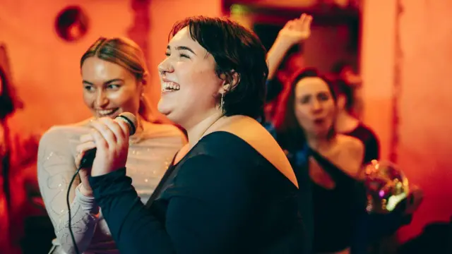Tres mujeres cantando y bailando 